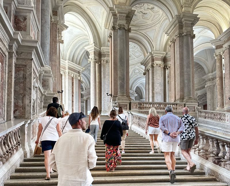 People exploring a historic building filled with ancient ruins and cultural artifacts in the Amalfi Coast.
