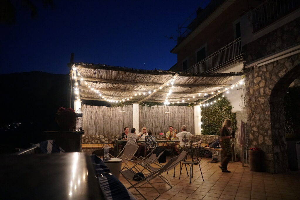 Group of travelers enjoying a meal together in their beautiful villa on the Amalfi Coast.
